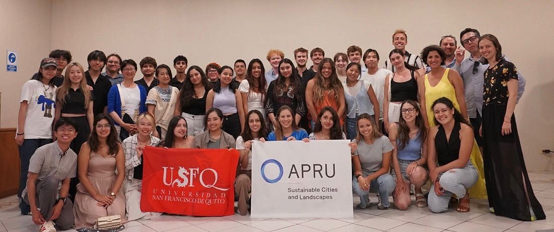 Group of university students holding a sign that says USFQ and APRU