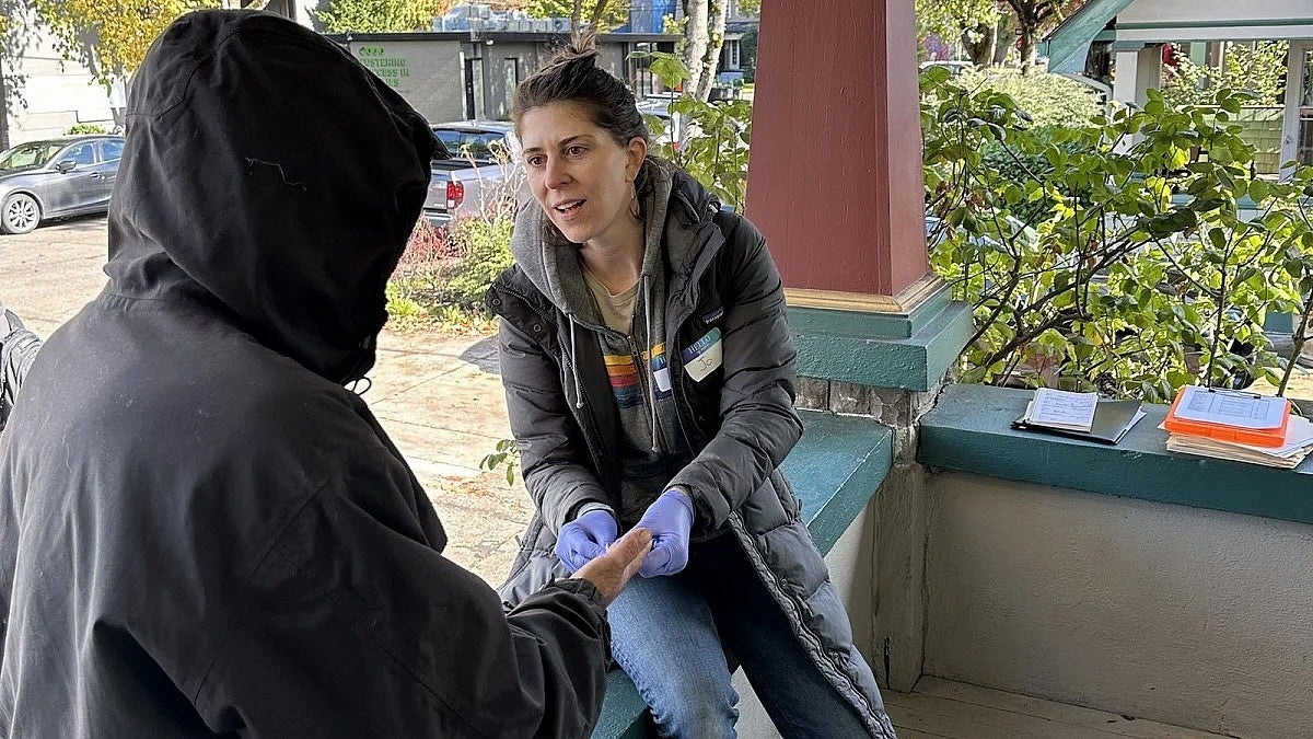 professor jo weaver speaks with an individual experiencing homelessness