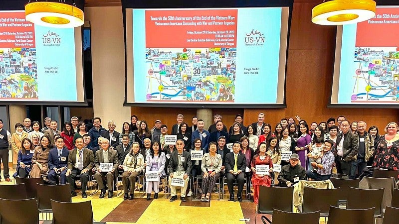 Attendees of the Vietnam 50th Anniversary stand for a photo in the Ford Alumni Center