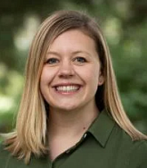 Woman with medium length blonde hair wearing a green collard shirt